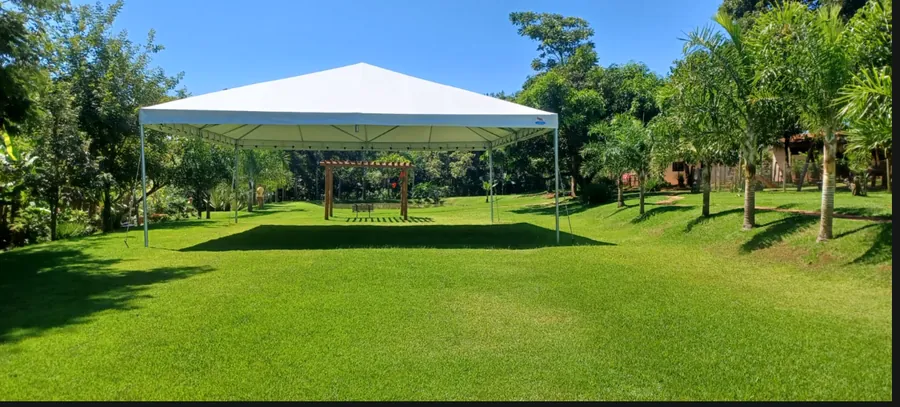Tenda piramidal montada em ampla área verde com piscina pela Lider Arte Tendas