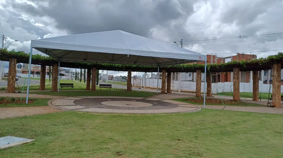 Tenda piramidal montada em praça com pergolado de madeira